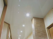 Вид натяжного белого потолка со светильниками