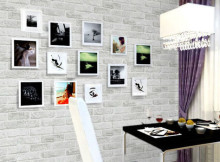 Белые рамки фотографий на фоне серой кирпичной стены