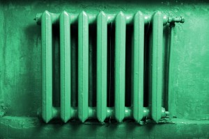 Старая чугунная батарея отопления зелёного цвета